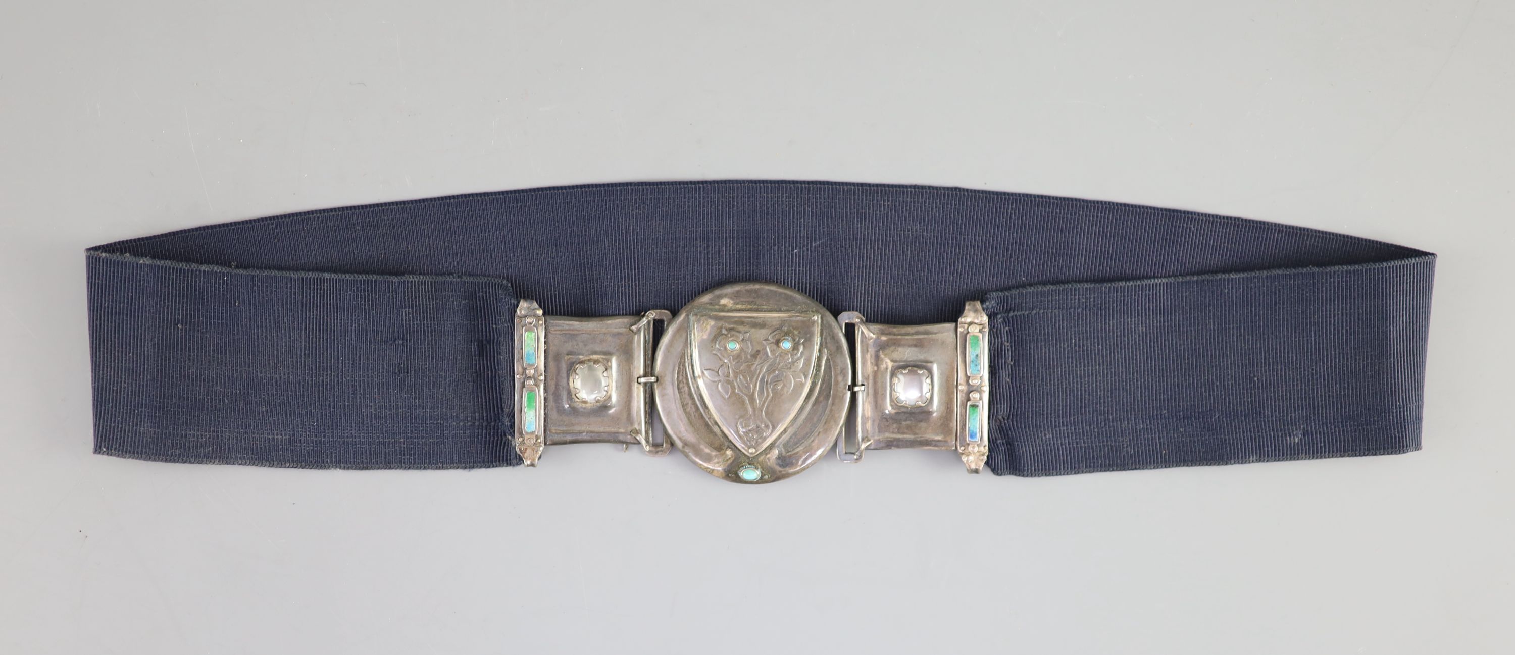 An early 20th century Arts & Crafts silver, enamel, turquoise and cabochon moonstone mounted buckle, on a sash belt